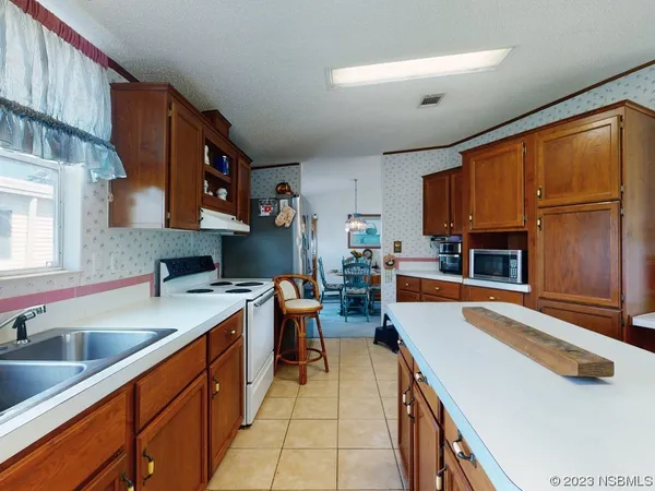 a kitchen filled counter top space a sink cabinets and a window