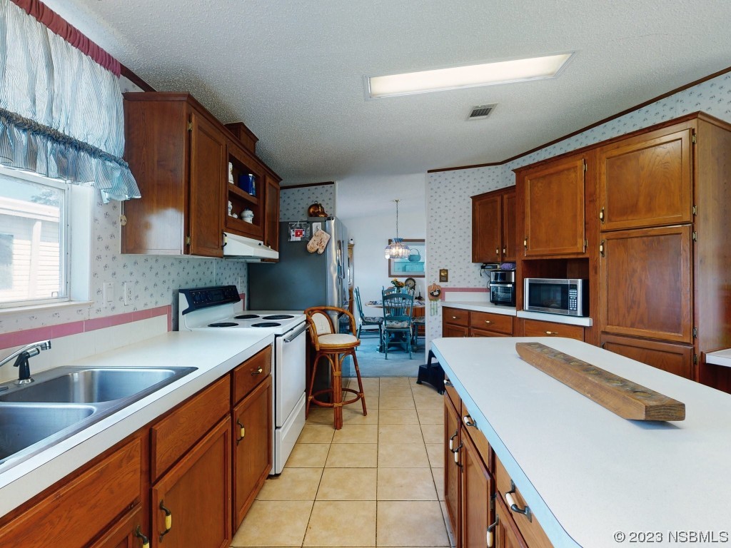 700 Starboard Avenue Edgewater, FL 32141 - Photo 13 of 47 a kitchen filled counter top space a sink cabinets and a window