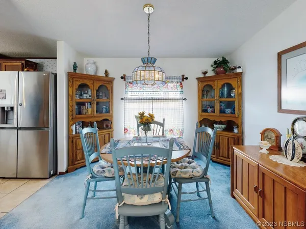a dining room with furniture a chandelier and wooden floor