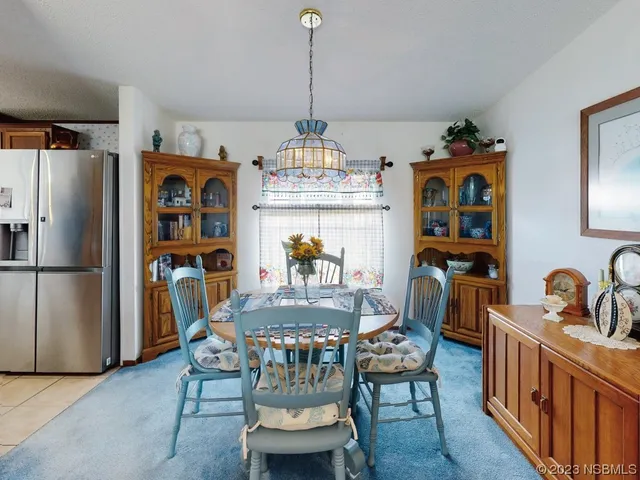 a dining room with furniture a chandelier and wooden floor