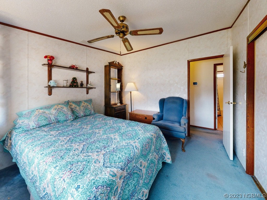 700 Starboard Avenue Edgewater, FL 32141 - Photo 19 of 47 a bedroom with a bed and a chandelier