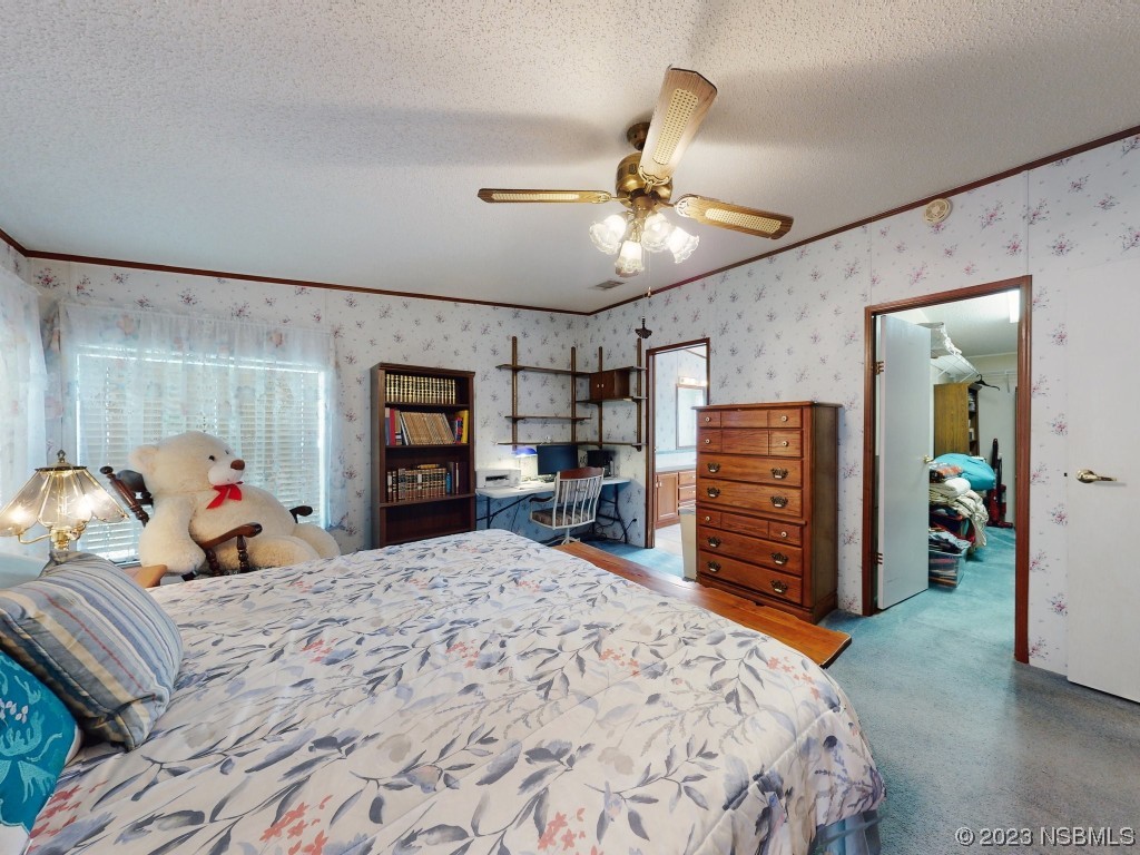 700 Starboard Avenue Edgewater, FL 32141 - Photo 23 of 47 a bedroom with a bed and a chandelier