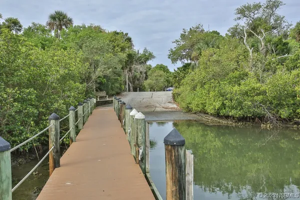 a view of a patio with table and chairs with wooden floor and fence