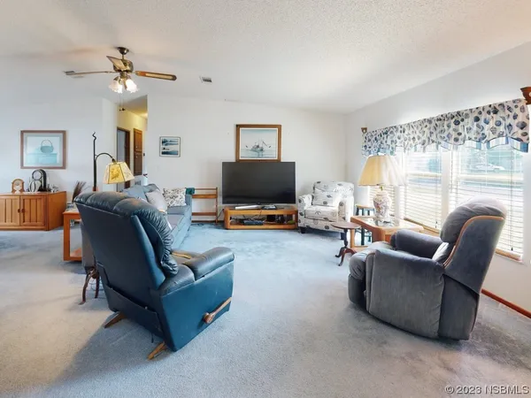 a living room with furniture window and a flat screen tv