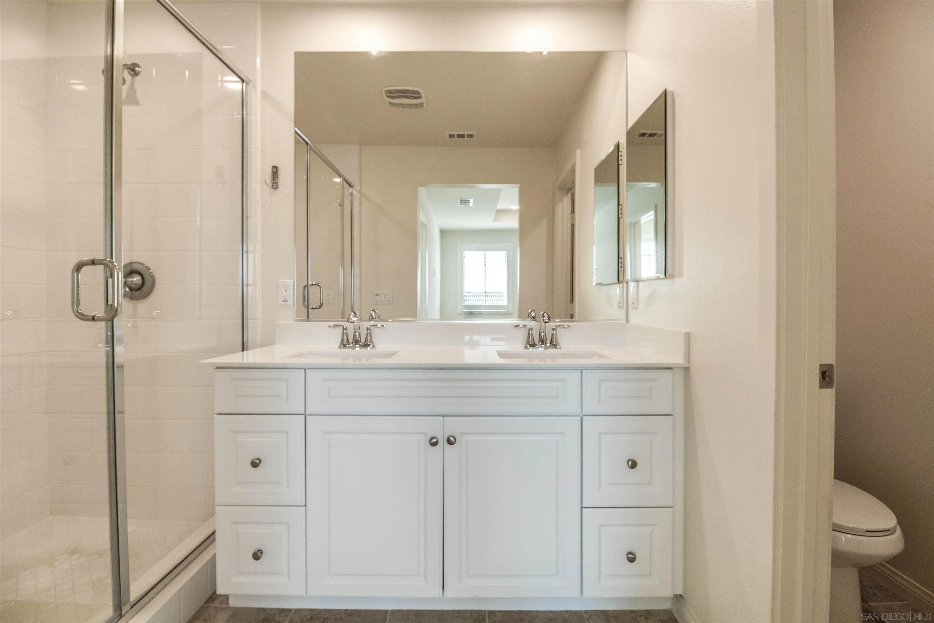 6012 Village Center Loop Road, Unit 35 San Diego, CA 92130 - Photo 12 of 29 a bathroom with double vanity sink a mirror and a shower