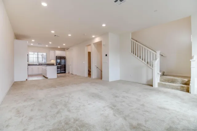 a view of empty room with windows and refrigerator