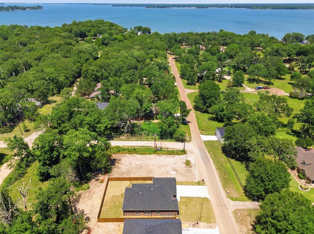 435 Waterboard Road Trinidad, TX 75163 - Photo 3 of 39 Aerial perspective showcasing a parcel of land with partial fencing and a newly constructed structure, surrounded by mature trees and a distant body of water