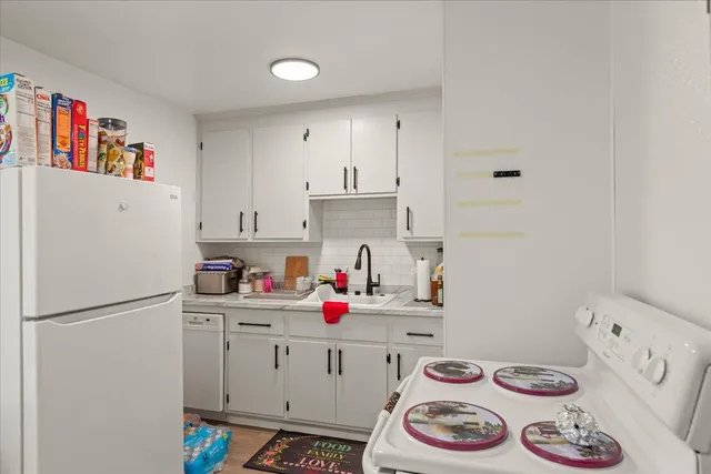 a kitchen with a refrigerator and white stove top oven