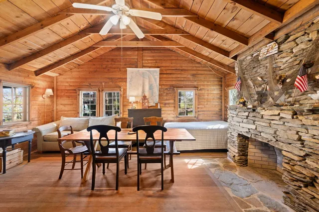 a dining hall with couches a flat screen tv and fireplace