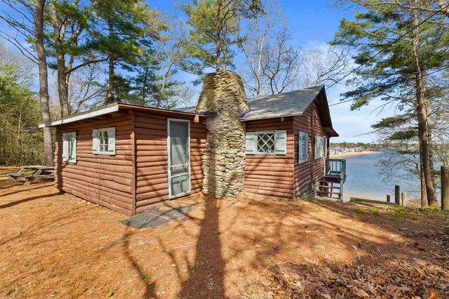 a view of a house with large trees and wooden fence