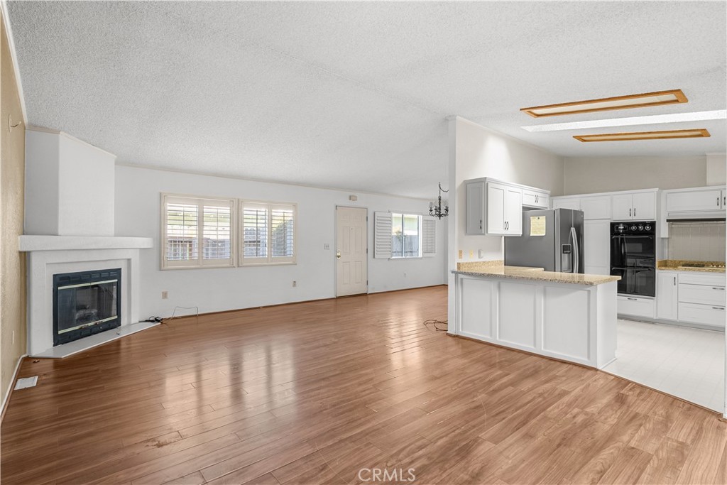 820 Vista Del Rio Santa Maria, CA 93458 - Photo 9 of 57 a view of an empty room and a kitchen with wooden floor and a kitchen