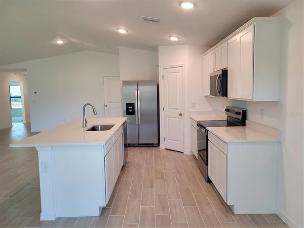 a kitchen with stainless steel appliances granite countertop a sink and a stove top oven