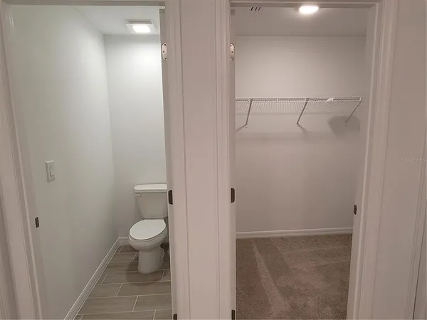 a bathroom with a granite countertop shower and a toilet