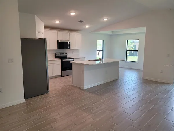 a view of kitchen with microwave and refrigerator