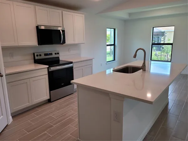 a kitchen with stainless steel appliances a stove a sink a microwave and cabinets