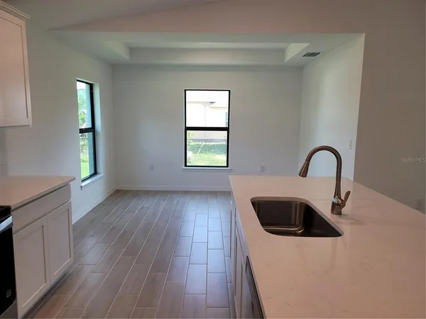 a view of a kitchen with a sink dishwasher and wooden floor