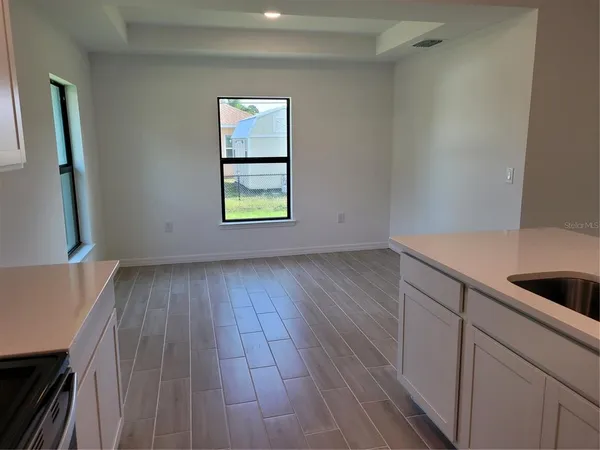 a view of a kitchen with wooden floor and a window