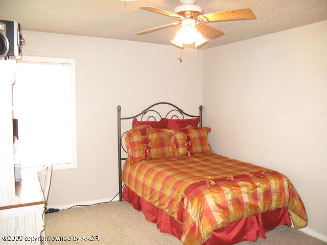 3618 South Ong Street Amarillo, TX 79110 - Photo 6 of 17 a bedroom with a bed and a chandelier