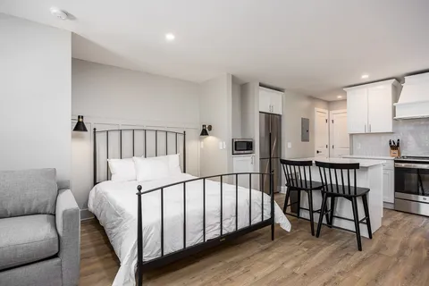 a kitchen with cabinets stainless steel appliances and wooden floor