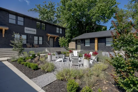 a kitchen with stainless steel appliances granite countertop a stove a sink dishwasher a refrigerator and white cabinets with wooden floor