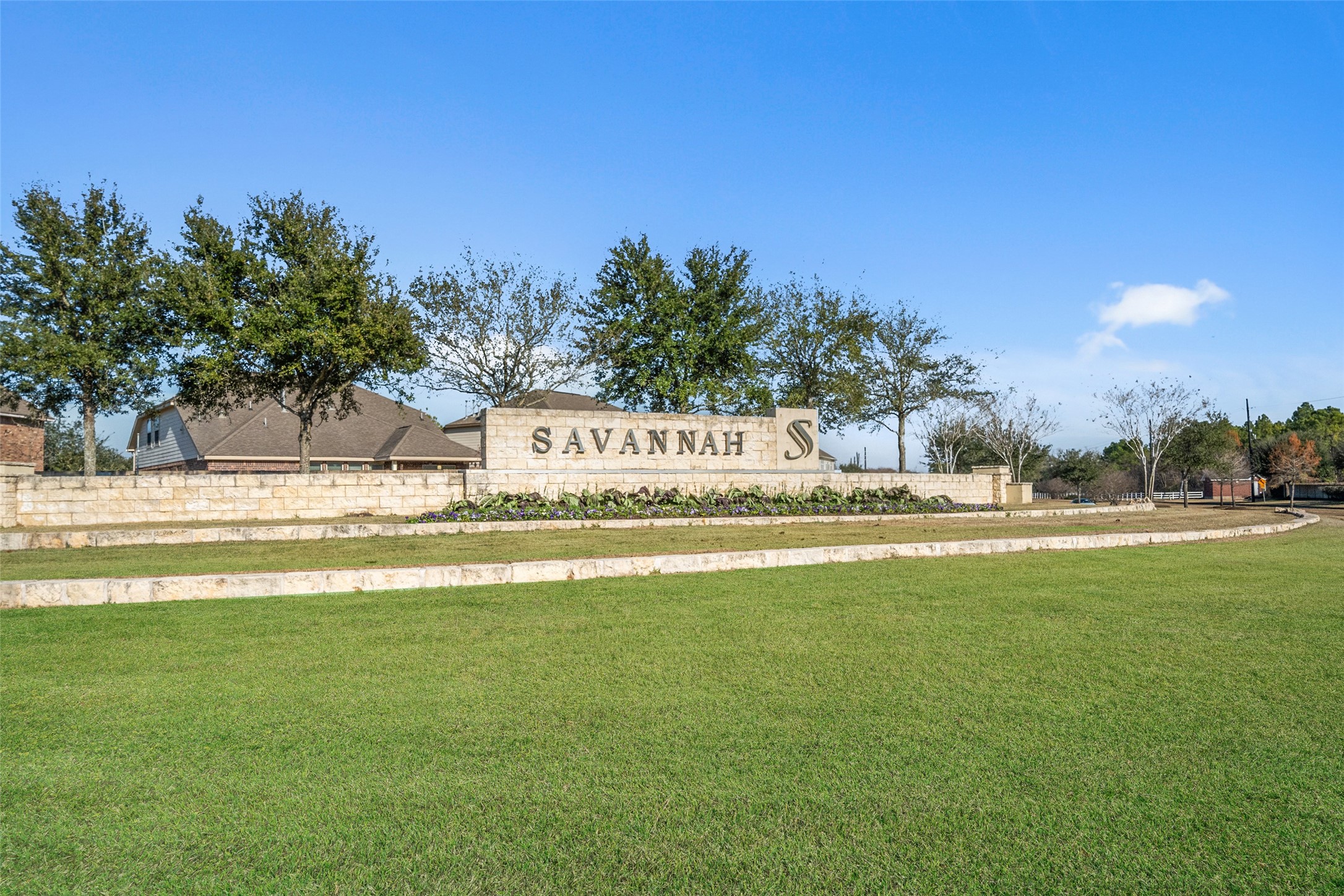 4747 Abercorn Street Rosharon, TX 77583 - Photo 37 of 46 Entrance to a community named Savannah, featuring a stone sign with well-maintained landscaping and surrounding greenery.