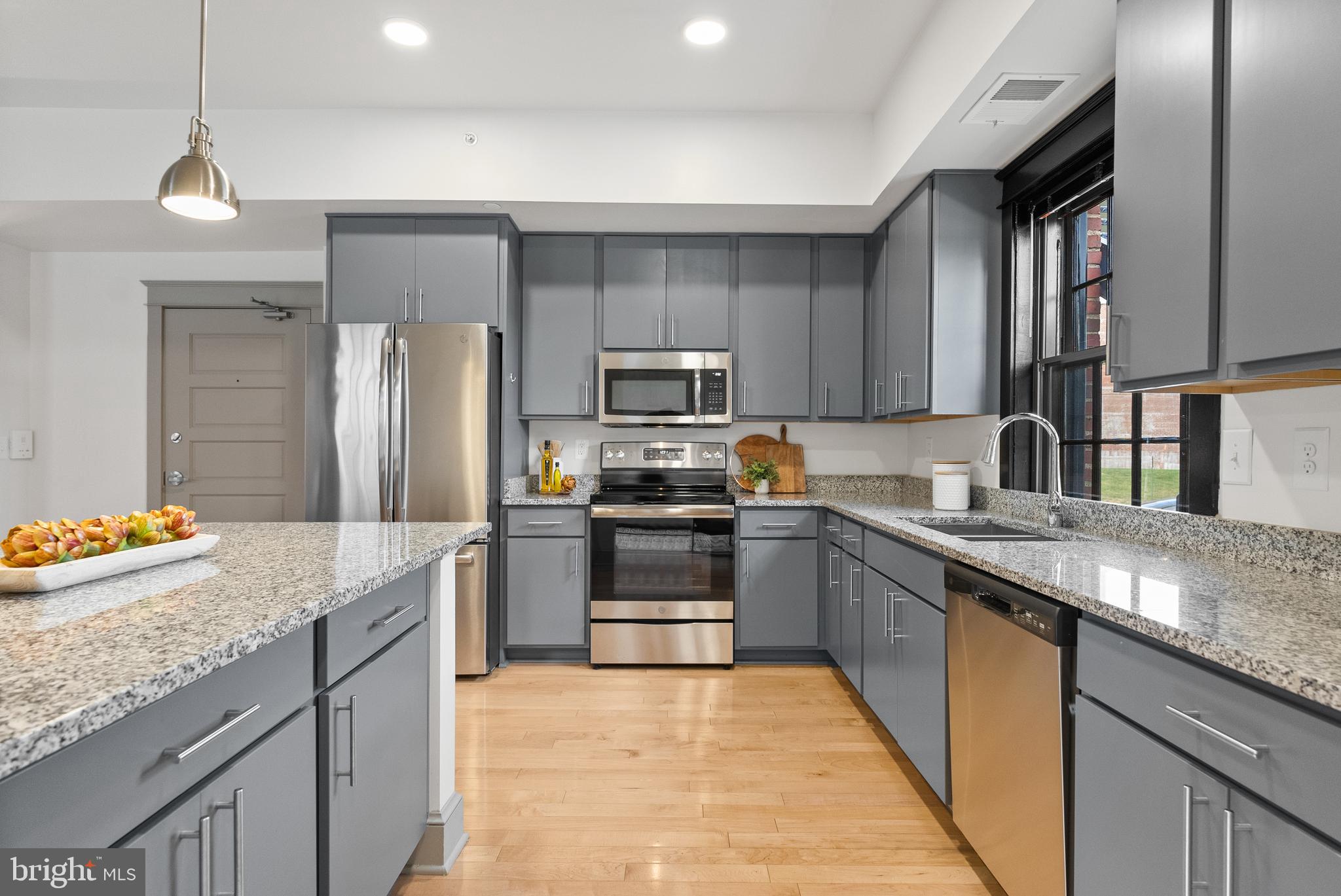 9071 Power House Road, Unit 102 Lorton, VA 22079 - Photo 11 of 53 a kitchen with granite countertop stainless steel appliances and wooden cabinets