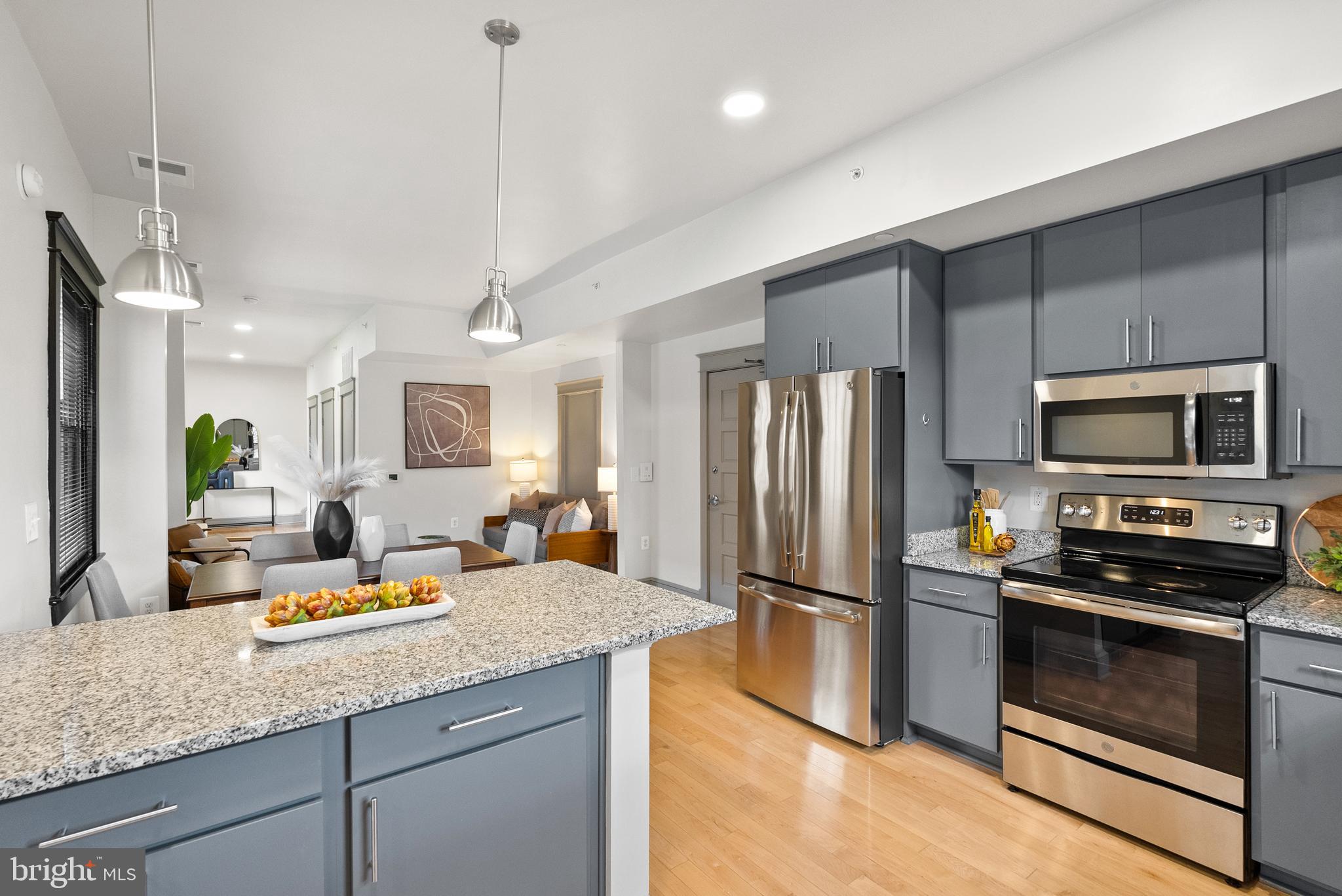 9071 Power House Road, Unit 102 Lorton, VA 22079 - Photo 16 of 53 a kitchen with stainless steel appliances granite countertop a refrigerator a stove a sink and a refrigerator with wooden floor