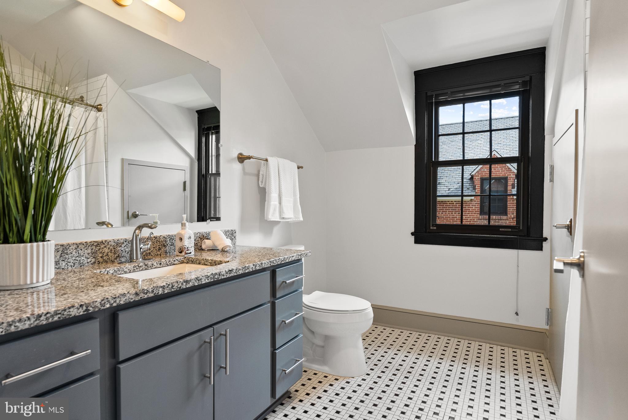 9071 Power House Road, Unit 102 Lorton, VA 22079 - Photo 34 of 53 a bathroom with a granite countertop sink toilet a mirror and a shower