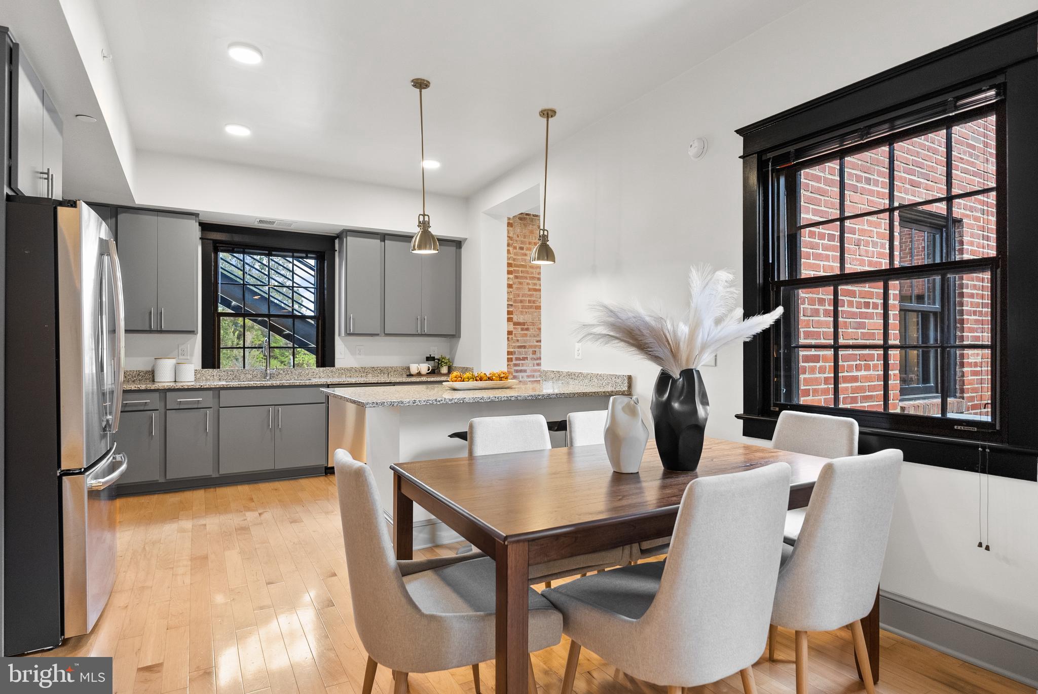 9071 Power House Road, Unit 102 Lorton, VA 22079 - Photo 9 of 53 a kitchen with stainless steel appliances kitchen island granite countertop a refrigerator a stove a sink dishwasher with a dining table and chairs