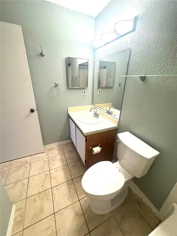 a bathroom with a sink a toilet a mirror and vanity