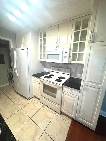a kitchen with a stove a refrigerator and a window