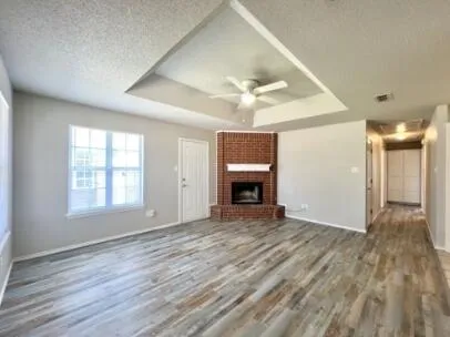 a view of empty room with wooden floor and fireplace