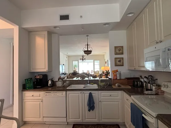 a kitchen with a white cabinets and window