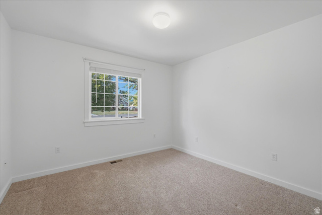 791 East Saddle Road Grantsville, UT 84029 - Photo 22 of 46 Bright interior space featuring a window with exterior scenery, neutral carpeting, white painted walls, and a ceiling-mounted light fixture