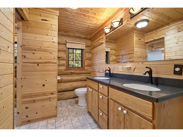a bathroom with a granite countertop sink toilet a mirror and shower