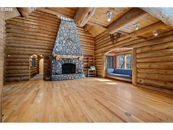 a view of empty room with wooden floor and fireplace