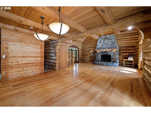 a view of empty room with a fireplace and wooden floor