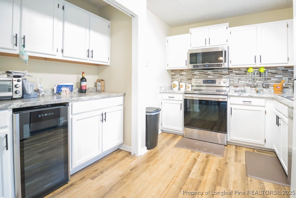 5014 Summer Ridge Road Fayetteville, NC 28303 - Photo 12 of 20 a kitchen with granite countertop a stove top oven and cabinets