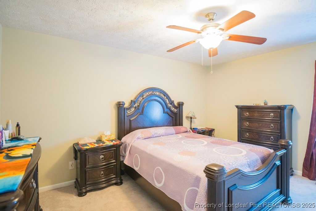 5014 Summer Ridge Road Fayetteville, NC 28303 - Photo 14 of 20 a bedroom with a bed and a chandelier