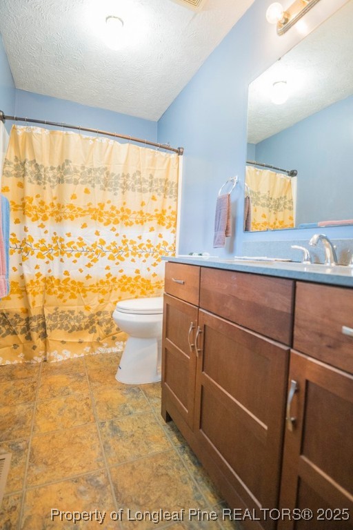 5014 Summer Ridge Road Fayetteville, NC 28303 - Photo 16 of 20 a bathroom with a sink a toilet and a shower curtain
