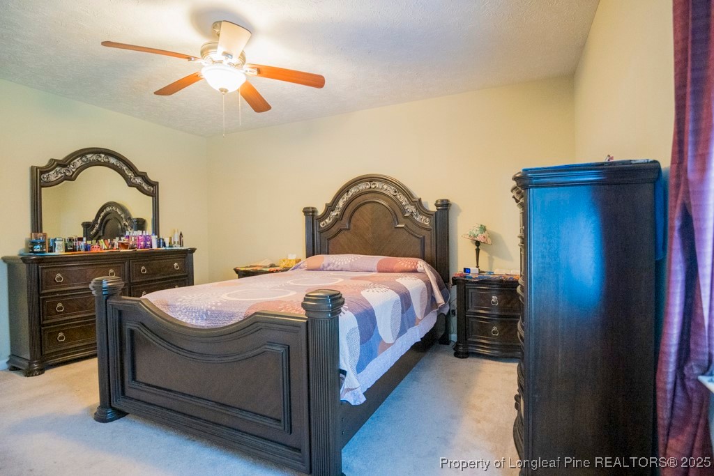 5014 Summer Ridge Road Fayetteville, NC 28303 - Photo 17 of 20 a spacious bedroom with a bed and a dresser