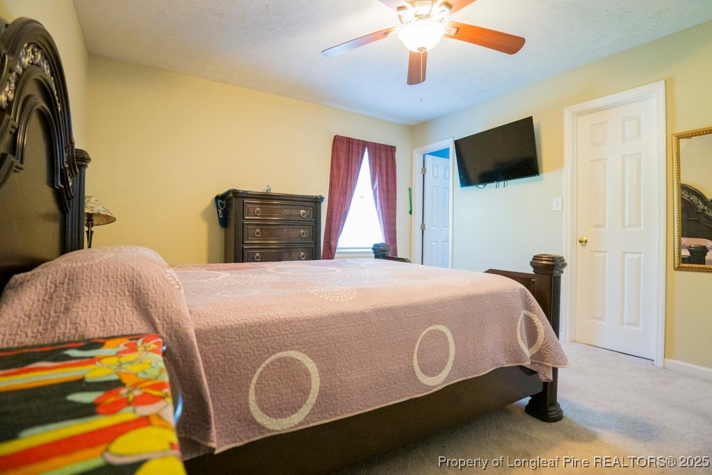 5014 Summer Ridge Road Fayetteville, NC 28303 - Photo 18 of 20 a bed sitting in a bedroom and a flat screen tv