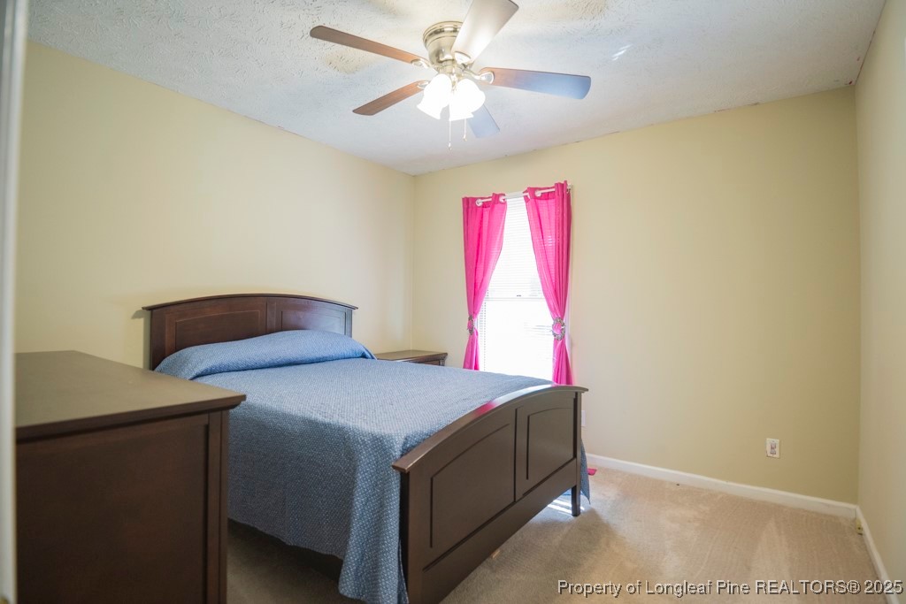 5014 Summer Ridge Road Fayetteville, NC 28303 - Photo 19 of 20 a bedroom with a bed and a chandelier