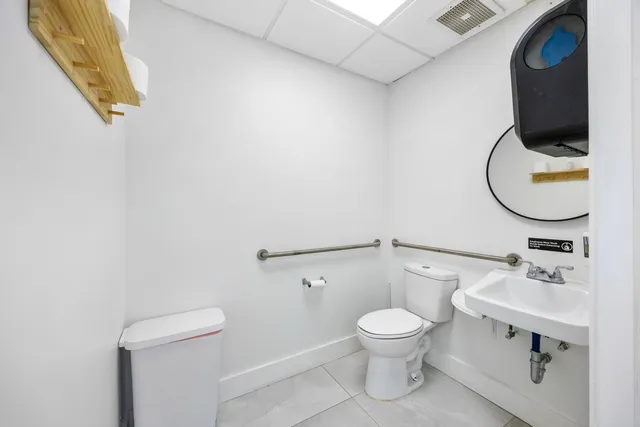 a bathroom with a toilet a sink and mirror