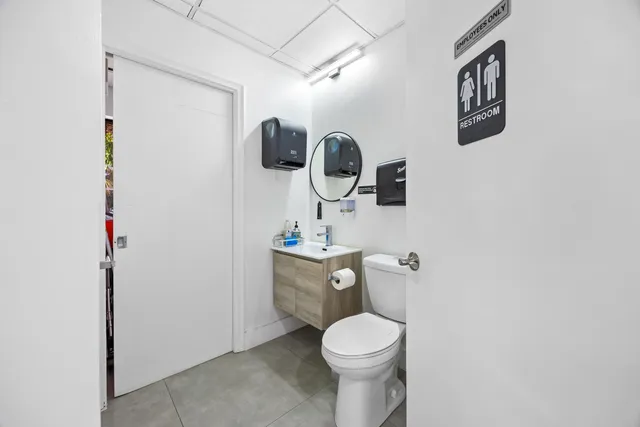a bathroom with a toilet a sink and mirror