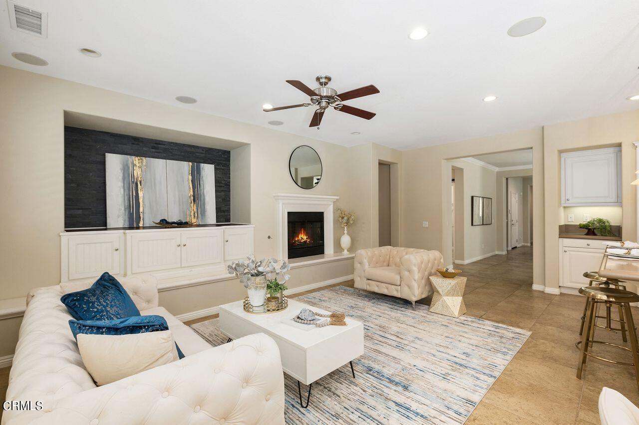 11249 Figtree Terrace Road Corona, CA 92883 - Photo 11 of 53 a living room with furniture a fireplace and a ceiling fan