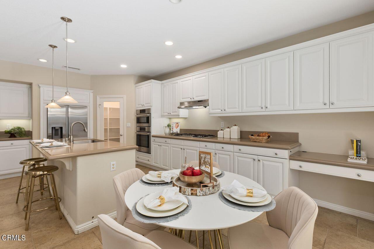 11249 Figtree Terrace Road Corona, CA 92883 - Photo 16 of 53 a kitchen with stainless steel appliances kitchen island granite countertop a white table and chairs in it
