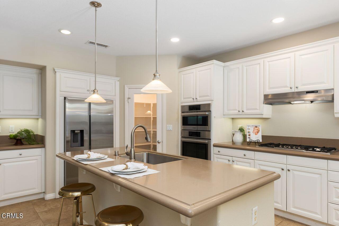11249 Figtree Terrace Road Corona, CA 92883 - Photo 17 of 53 a kitchen with stainless steel appliances granite countertop a sink a stove and a refrigerator