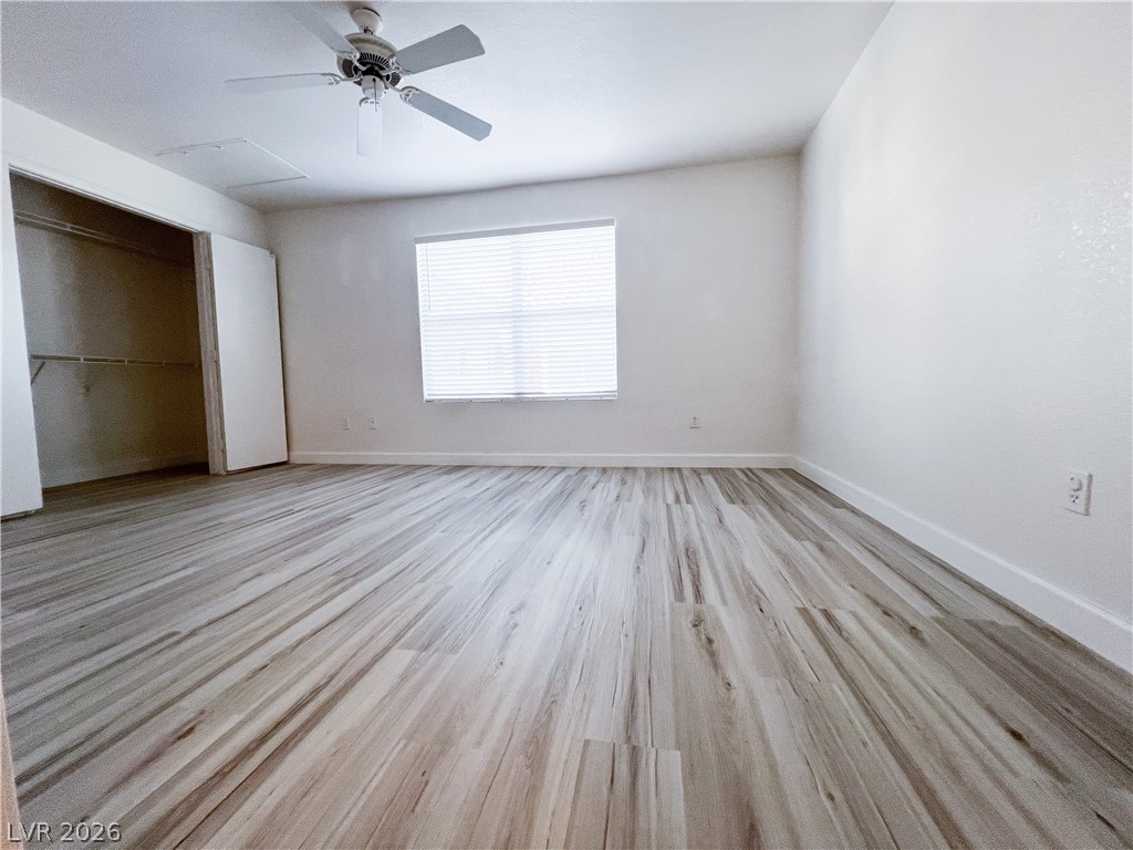 8101 West Flamingo Road, Unit 2129 Las Vegas, NV 89147 - Photo 5 of 12 A luminous bedroom featuring a ceiling fan and elegant wood flooring for comfortable living.