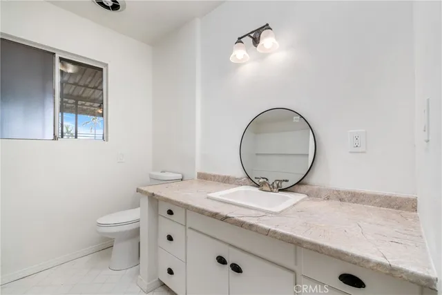 a bathroom with a toilet a sink and mirror